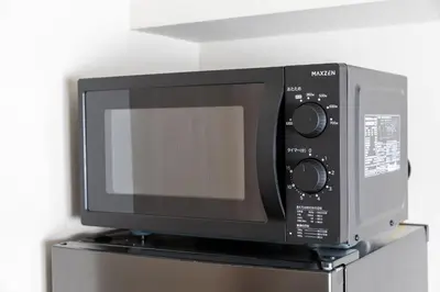 a microwave oven sitting on top of a refrigerator at \u30d6\u30e9\u30f3\u30d9\u30fc\u30b9\u6771\u4eac\u516d\u7fa9\u5712 ss in Tokyo