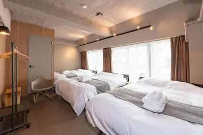 a hotel room with three beds and a window at \u30d6\u30e9\u30f3\u30d9\u30fc\u30b9\u6771\u4eac\u516d\u7fa9\u5712 aw in Tokyo