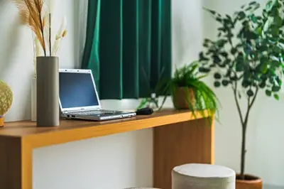 a laptop computer sitting on top of a wooden table at AT Asakusa in Tokyo
