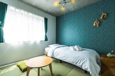 a bedroom with two beds and a table and a window at AT Asakusa in Tokyo