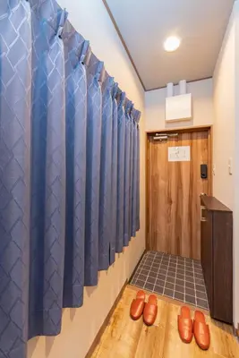 a room with blue curtains and brown shoes at \u6d45\u8349\u30a2\u30d1\u30fc\u30c8\u30e1\u30f3\u30c8 401 in Tokyo