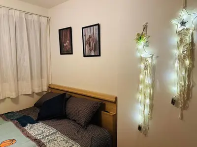 a bedroom with a bed and lights on the wall at Jr \u65b0\u5927\u4e45\u4fdd\u8eca\u7ad9\u5f92\u6b696\u5206 \u65b0\u5efa\u7368\u68df\u6d0b\u623f\u6700\u59278\u4eba\u5165\u4f4f \u96fb\u8eca9\u5206\u76f4\u9054\u6d89\u8c37 in Tokyo