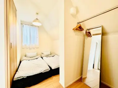a small room with a bed and a mirror at Jr \u65b0\u5927\u4e45\u4fdd\u8eca\u7ad9\u5f92\u6b696\u5206 \u65b0\u5efa\u7368\u68df\u6d0b\u623f\u6700\u59278\u4eba\u5165\u4f4f \u96fb\u8eca9\u5206\u76f4\u9054\u6d89\u8c37 in Tokyo