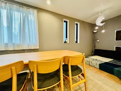 a dining room with a wooden table and chairs at Jr \u65b0\u5927\u4e45\u4fdd\u8eca\u7ad9\u5f92\u6b696\u5206 \u65b0\u5efa\u7368\u68df\u6d0b\u623f\u6700\u59278\u4eba\u5165\u4f4f \u96fb\u8eca9\u5206\u76f4\u9054\u6d89\u8c37 in Tokyo