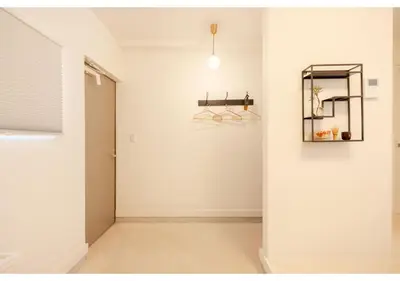 a hallway with a white wall and a mirror at Lido Alba in Tokyo