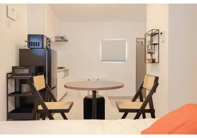 a room with a table and chairs and a kitchen at Lido Alba in Tokyo