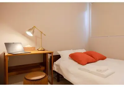 a bedroom with a bed and a desk with a laptop at Lido Alba in Tokyo