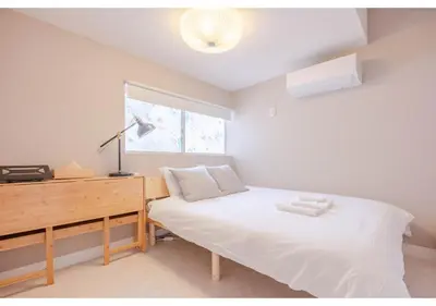 a bedroom with a bed and a desk and a window at Lido Blu in Tokyo