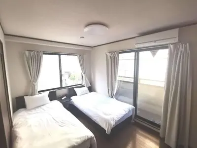 a bedroom with two beds and a large window at Oshiage Sta U-Court Kinshicho in Tokyo