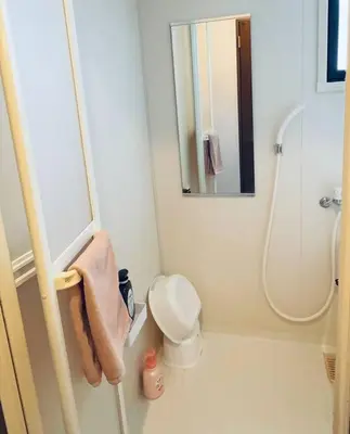 a bathroom with a toilet and a shower with a mirror at Oshiage Sta U-Court Kinshicho in Tokyo