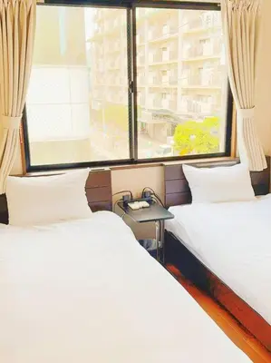 two beds in a room with a window at U-Court Kinshicho 3F in Tokyo