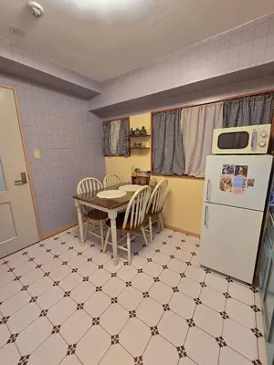 a kitchen with a table and a white refrigerator at ueno minowa 602 in Tokyo