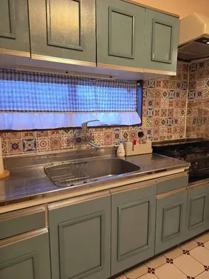 a kitchen with green cabinets and a sink at ueno minowa 602 in Tokyo