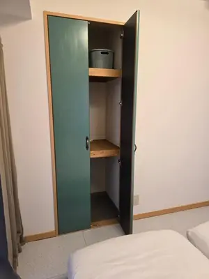 a closet with a green door next to a bed at ueno minowa 602 in Tokyo