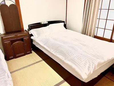 a bedroom with a bed with white sheets and a dresser at \u5e1d\u4eac\u5927\u5b66\u4ed8\u8fd1 \u5341\u6761 in Tokyo