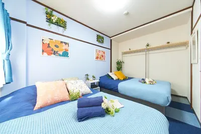 two beds in a room with blue at Belmont 101 3min to Station Easy Access Ueno Asakusa Skytree Sleeps 5 in Tokyo