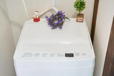 a white washing machine with flowers on top of it at Belmont 101 3min to Station Easy Access Ueno Asakusa Skytree Sleeps 5 in Tokyo