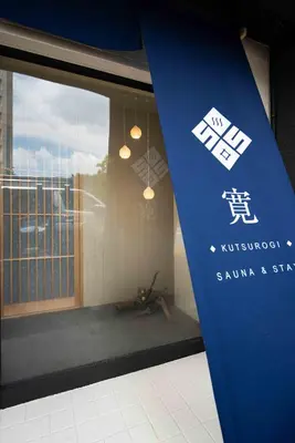 a sign in front of a window of a building at KUTSUROGI SAUNA and STAY in Tokyo