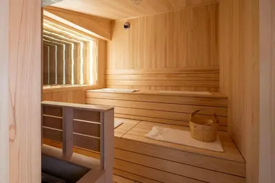 a wooden sauna with two benches and a bucket at KUTSUROGI SAUNA and STAY in Tokyo