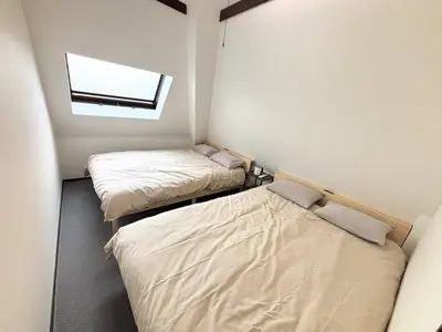 two beds in a small room with a window at \u6c60\u888b\u99c5\u307e\u3067\u96fb\u8eca\u30677\u5206 4LDK98m2 in Tokyo