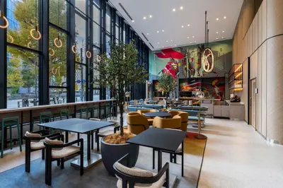 a restaurant with tables and chairs and windows at YOTEL Tokyo Ginza in Tokyo
