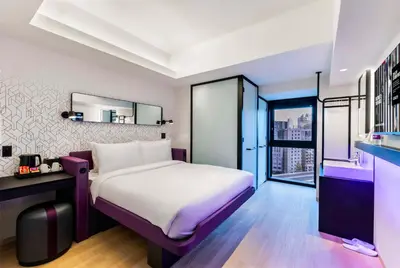 a bedroom with a large white bed and a window at YOTEL Tokyo Ginza in Tokyo