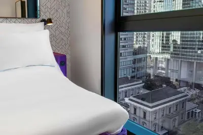 a bedroom with a bed and a large window at YOTEL Tokyo Ginza in Tokyo