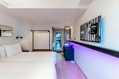 a hotel room with a white bed and a corridor at YOTEL Tokyo Ginza in Tokyo