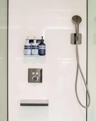 a shower in a bathroom with three bottles on the wall at YOTEL Tokyo Ginza in Tokyo