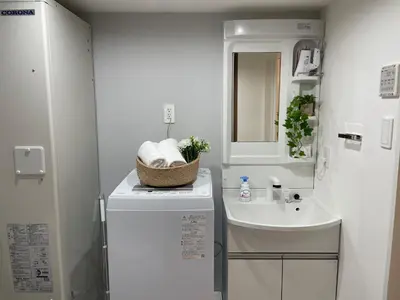 a small white bathroom with a sink and a counter at COMMA HOUSE Otsuka 201 in Tokyo