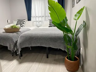 a bedroom with a bed and a potted plant at COMMA HOUSE Otsuka 201 in Tokyo