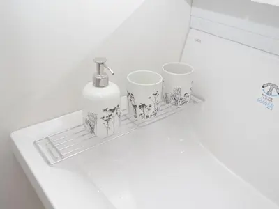 a shelf with a bottle and four cups on it at City Pal Sakurashinmachi - Vacation STAY 17738 in Tokyo