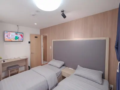 a hotel room with two beds and a desk at City Pal Sakurashinmachi - Vacation STAY 17738 in Tokyo