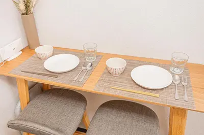 a wooden table with white plates and glasses on it at \u65b0\u5bbf\u6b4c\u821e\u4f0e\u753a\u7e41\u534e\u5546\u4e1a\u533a\u514d\u8d39Wi-Fi#9 in Tokyo