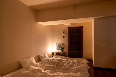 a bedroom with a bed with a white comforter at \u30b5\u30cb\u30fc\u30cf\u30a4\u30c4 in Tokyo