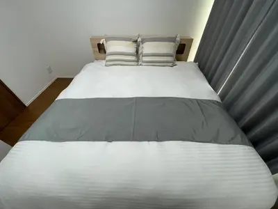 a bed with white sheets and pillows in a bedroom at Starry Ocean in Tokyo