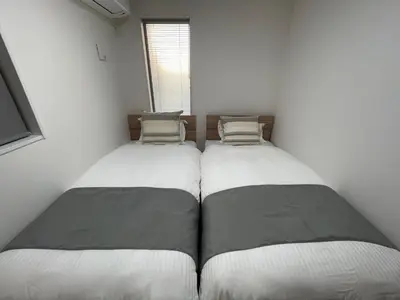 two twin beds in a room with a window at Starry Ocean in Tokyo