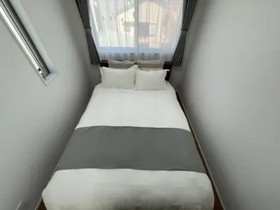 a small bed in a small room with a window at Starry Ocean in Tokyo