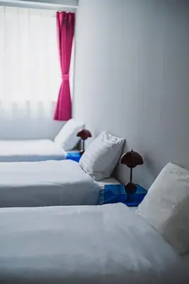 three white beds in a room with a window at Streamer \u685c\u4e18\u753a House Shibuya station in Tokyo