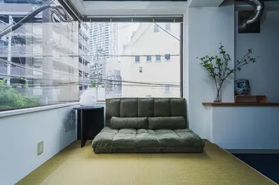 a couch sitting in a room with a large window at Streamer \u685c\u4e18\u753a House Shibuya station in Tokyo