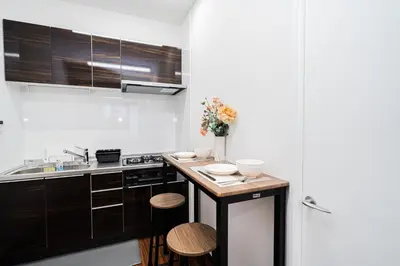 a kitchen with a counter with some flowers on it at Momostay Skytree\u524d\u4f11\u696d\u4e2d in Tokyo