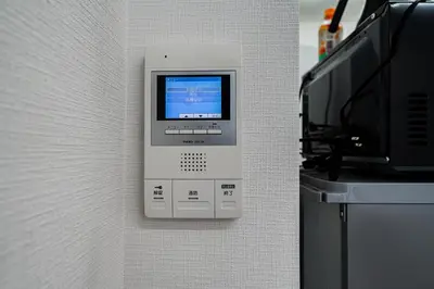 a phone is hanging on a wall next to a microwave at Momostay Skytree\u524d\u4f11\u696d\u4e2d in Tokyo