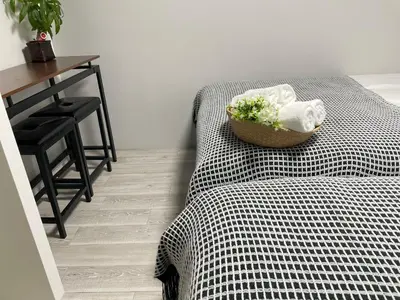 a bedroom with a bed and a desk and a table with towels at COMMA HOUSE Otsuka 203 in Tokyo