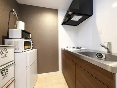a kitchen with a sink and a microwave at - KOMA Hotel- \u6d45\u8349\u99c5\u5f92\u6b696\u5206 \u7bc9\u6d45\u3067Wi-Fi\u4ed8\u304d \u5bb6\u5177\u5bb6\u96fb\u5145\u5b9f in Tokyo