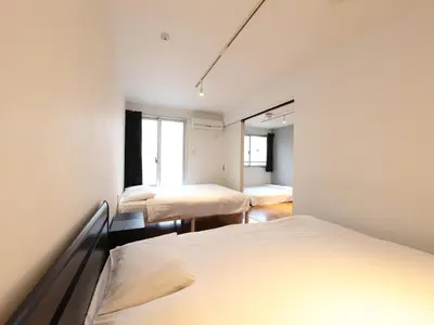 a room with three beds and a window at - KOMA Hotel- \u6d45\u8349\u99c5\u5f92\u6b696\u5206 \u7bc9\u6d45\u3067Wi-Fi\u4ed8\u304d \u5bb6\u5177\u5bb6\u96fb\u5145\u5b9f in Tokyo