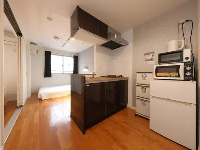 a small kitchen with a counter and a microwave at - KOMA Hotel- \u6d45\u8349\u99c5\u5f92\u6b696\u5206 \u7bc9\u6d45\u3067Wi-Fi\u4ed8\u304d \u5bb6\u5177\u5bb6\u96fb\u5145\u5b9f in Tokyo