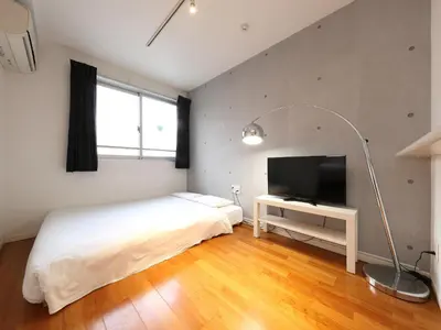 a bedroom with a bed and a flat screen tv at - KOMA Hotel- \u6d45\u8349\u99c5\u5f92\u6b696\u5206 \u7bc9\u6d45\u3067Wi-Fi\u4ed8\u304d \u5bb6\u5177\u5bb6\u96fb\u5145\u5b9f in Tokyo