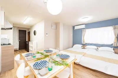 a bedroom with a bed and a table and chairs at \u6d45\u8349\u30a2\u30d1\u30fc\u30c8\u30e1\u30f3\u30c8301 in Tokyo