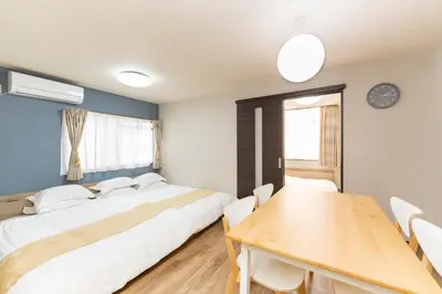 a bedroom with a bed and a wooden table at \u6d45\u8349\u30a2\u30d1\u30fc\u30c8\u30e1\u30f3\u30c8301 in Tokyo