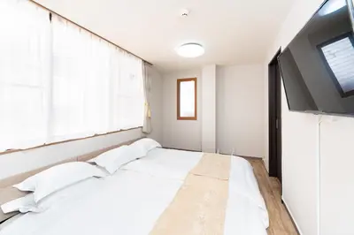 a bedroom with a bed and a flat screen tv at \u6d45\u8349\u30a2\u30d1\u30fc\u30c8\u30e1\u30f3\u30c8301 in Tokyo